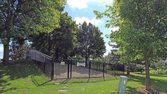 a wrought iron fence surrounds a park with trees